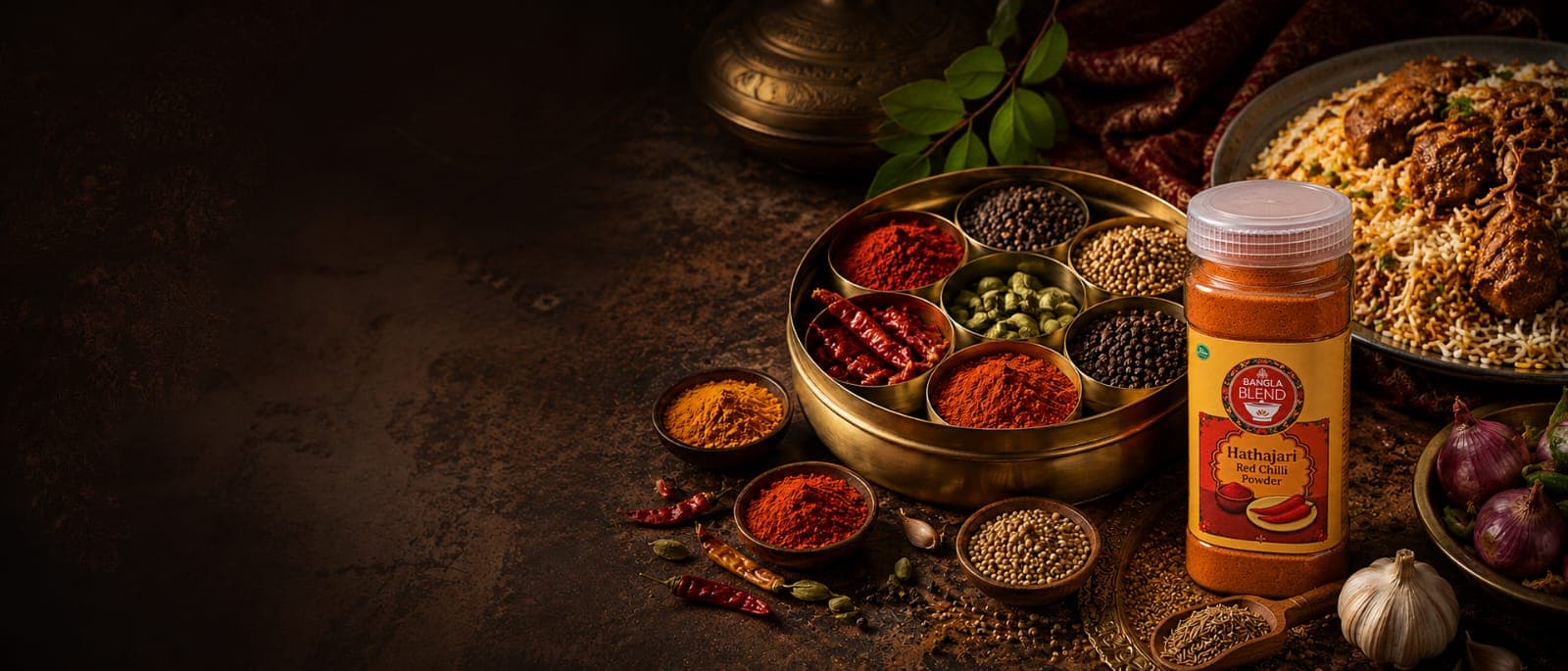 Bangla Blend red chilli powder surrounded by whole spices and a Bengali meal